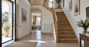 Ingresso di una casa su due livelli con scala interna e radiatore al piano inferiore